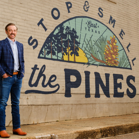 Man standing in front of mural that says 