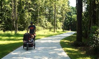 Dad jogs on Guthrie Trail with stroller