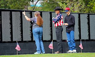 People look at names on the Veteran's Plaza wall, Longview, TX
